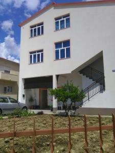 a white house with a fence in front of it at Apartments with a parking space Kastel Novi, Kastela - 16018 in Kaštela