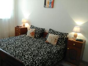 1 dormitorio con cama con sábanas y almohadas blancas y negras en Apartments with a parking space Kastel Novi, Kastela - 16018 en Kaštela