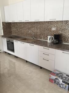 a kitchen with white cabinets and a sink at Apartments with a parking space Podstrana, Split - 16032 in Podstrana