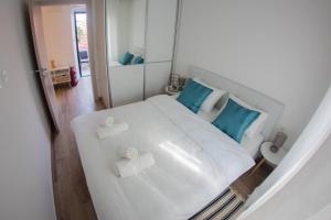 a bedroom with a white bed with blue pillows at Apartments by the sea Gradac, Makarska - 16039 in Gradac