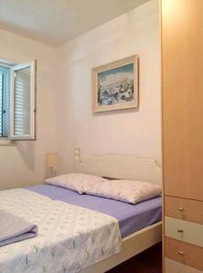 a bedroom with a bed and a painting on the wall at Holiday house with a parking space Zaostrog, Makarska - 16043 in Zaostrog