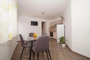 een keuken en eetkamer met een tafel en stoelen bij Apartments with a parking space Zrnovo, Korcula - 16045 in Korčula