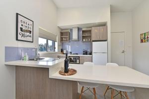 a kitchen with a white counter top and a sink at Ironbark Hill Villa 1 Tyrian in Pokolbin