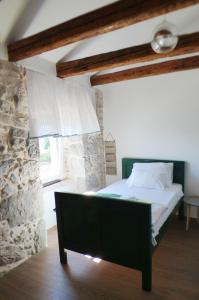 a bedroom with a bed and a stone wall at Holiday house with a parking space Skrbcici, Krk - 16084 in Vrh