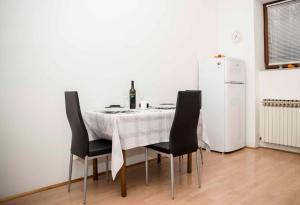 una mesa con sillas y una botella de vino. en Apartments with WiFi Zagreb - 16085, en Zagreb