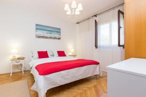 a bedroom with a large bed with red pillows at Apartments with parking space Kastel Stafilic, Kastela - 16086 in Kaštela