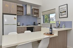 a kitchen with a counter with a bottle of wine at Ironbark Hill Villa 2 Aneis in Pokolbin