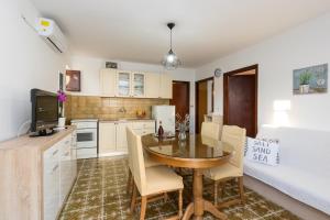 a kitchen with a table and chairs in a room at Apartments with a parking space Kastel Stafilic, Kastela - 16086 in Kaštela
