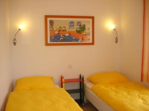 - une chambre avec 2 lits et une photo sur le mur dans l'établissement Grachtenstube, à Greetsiel