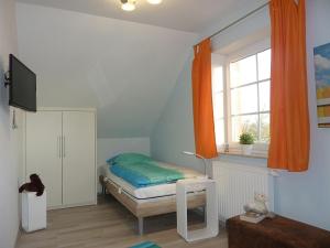 - une petite chambre avec un lit et une fenêtre dans l'établissement An den Zwillingsmühlen, à Greetsiel