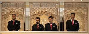 3 hommes en costumes debout devant une fenêtre dans l'établissement Royal Raj Hotel, à Râjshâhî