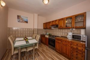 una cocina con armarios de madera y una mesa con sillas. en Apartments with a parking space Kastel Stari, Kastela - 16087, en Kaštela