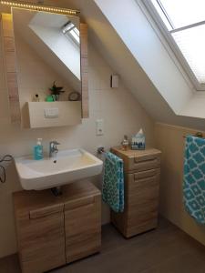 een badkamer met een wastafel en een spiegel bij Sielresidenz in Greetsiel