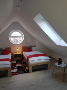 een zolderkamer met 2 bedden en een raam bij Sielresidenz in Greetsiel