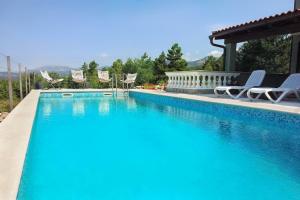 a large swimming pool with chairs and a gazebo at Holiday house with a swimming pool Smrika, Kraljevica - 16050 in Šmrika
