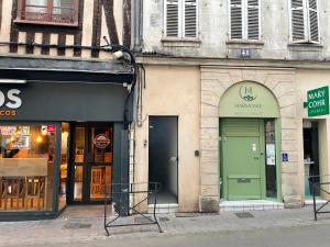 un edificio con una puerta verde en una calle en Appartement complet, hyper centre d’Auxerre., en Auxerre