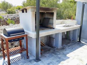 a outdoor kitchen with a sink and a stove at Apartments with a swimming pool Zrnovo, Korcula - 16116 in Korčula