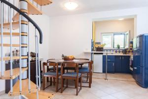 a kitchen with a table and chairs and blue cabinets at Holiday house with a parking space Gornji Tucepi, Makarska - 16113 in Tučepi