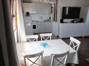 a kitchen with a white table and chairs and a kitchen with a refrigerator at Apartments with a swimming pool Zrnovo, Korcula - 16116 in Korčula