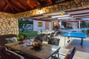 a patio with a ping pong table and a pool table at Seaside luxury villa with a swimming pool Cove Mihovilje, Pag - 16124 in Novalja