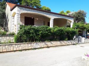 a house with a stone wall at Apartments by the sea Prigradica, Korcula - 16125 in Blato