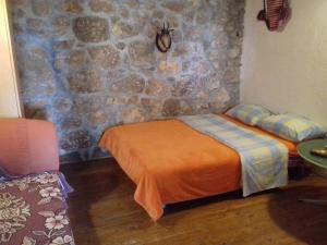 a bedroom with a bed and a stone wall at Holiday house with a parking space Starigrad, Paklenica - 16126 in Starigrad