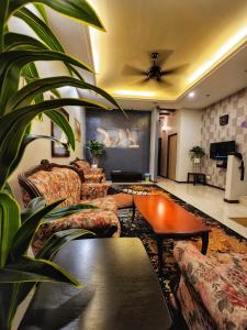 ein Wohnzimmer mit Sofas und einem Tisch in der Unterkunft StayLena Klebang Melaka Homestay - Musliem Unit in Malakka