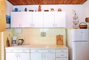 a kitchen with white cabinets and a white refrigerator at Seaside holiday house Sali, Dugi otok - 16128 in Sali