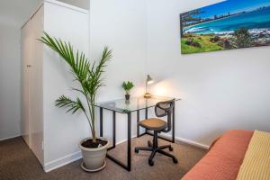 een bureau met een stoel en een plant in een kamer bij One-Bedroom Apartment on Summer in Orange