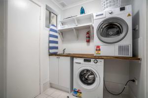 een kleine wasruimte met een wasmachine en droger bij One-Bedroom Apartment on Summer in Orange