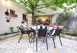 a table and chairs with pillows on a patio at Seaside holiday house Baska Voda, Makarska - 16138 in Baška Voda