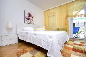 a white bedroom with a bed and a window at Seaside holiday house Baska Voda, Makarska - 16138 in Baška Voda