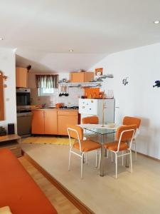eine Küche mit einem Glastisch und orangefarbenen Stühlen in der Unterkunft Apartments by the sea Baric Draga, Karlobag - 16148 in Barić Draga