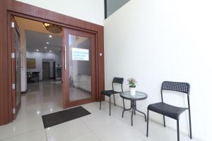 um quarto com duas cadeiras e uma mesa num edifício em Uptown Residence Syariah Pondok Pinang em Jacarta