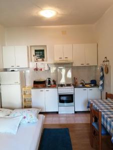 una cocina con armarios blancos y una cama en una habitación en Apartments by the sea Podgora, Makarska - 16159 en Podgora