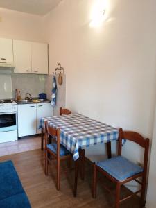 cocina con mesa y sillas en una habitación en Apartments by the sea Podgora, Makarska - 16159 en Podgora