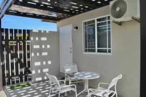 een patio met een tafel en stoelen en een raam bij Beach Homes Aruba in Noord