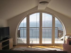 een woonkamer met een groot raam met uitzicht op de oceaan bij Apartments with a parking space Senj - 15376 in Senj