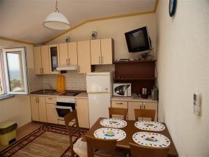 a kitchen with a table and two chairs and a kitchen with a table at Apartments and rooms by the sea Podaca, Makarska - 16114 in Podaca