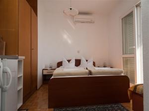 1 dormitorio con 1 cama, escritorio y nevera en Apartments and rooms by the sea Podaca, Makarska - 16114, en Podaca