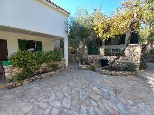 a house with a stone driveway in front of it at Holiday home Ivica - by the sea in Sevid