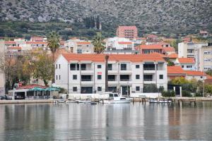 una barca è ormeggiata in un molo sull'acqua di Apartments by the sea Trogir - 16211 a Trogir