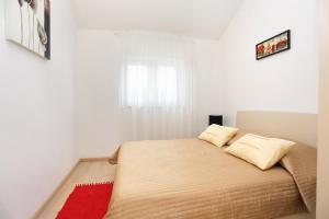 una camera con un letto con due cuscini sopra di Apartments by the sea Trogir - 16211 a Trogir