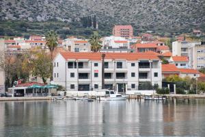 a boat is docked at a dock on the water at Apartments by the sea Trogir - 16210 in Trogir
