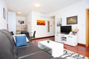 a living room with a couch and a tv at Apartments by the sea Trogir - 16210 in Trogir +32 photos