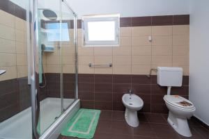 ein Bad mit einem WC, einer Dusche und einem Waschbecken in der Unterkunft Apartments with a parking space Bibinje, Zadar - 16188 in Bibinje