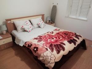 a bedroom with a bed with flowers on it at Apartments with a parking space Luka, Peljesac - 16229 in Ston