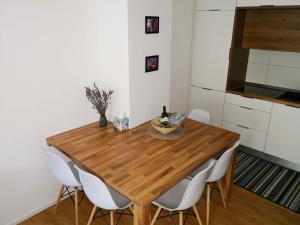 cocina con mesa de madera y sillas blancas en Apartments by the sea Vrsar, Porec - 16234 en Vrsar
