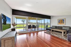 a living room with a couch and a table at Ironbark Hill Estate in Pokolbin