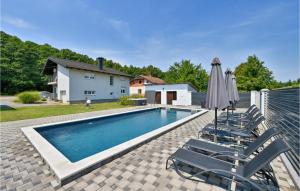 una piscina con sillas, una sombrilla y una casa en Cozy Home In Krizevci With House A Panoramic View, en Križevci